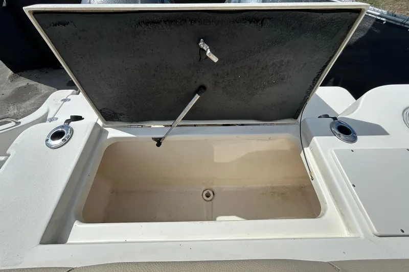 Slide: The Image of Open storage compartment on 2018 NauticStar 28 XS boat, featuring rod holders. - 44