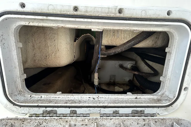 Slide: The Image of 2018 NauticStar 28 XS boat compartment with visible wiring and hoses. - 51