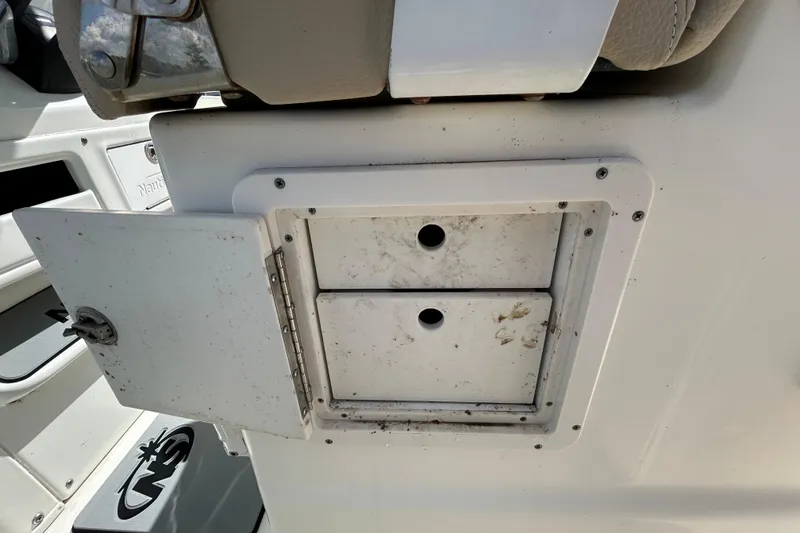 Slide: The Image of Storage compartment on a 2018 NauticStar 28 XS boat, featuring a hinged door. - 68