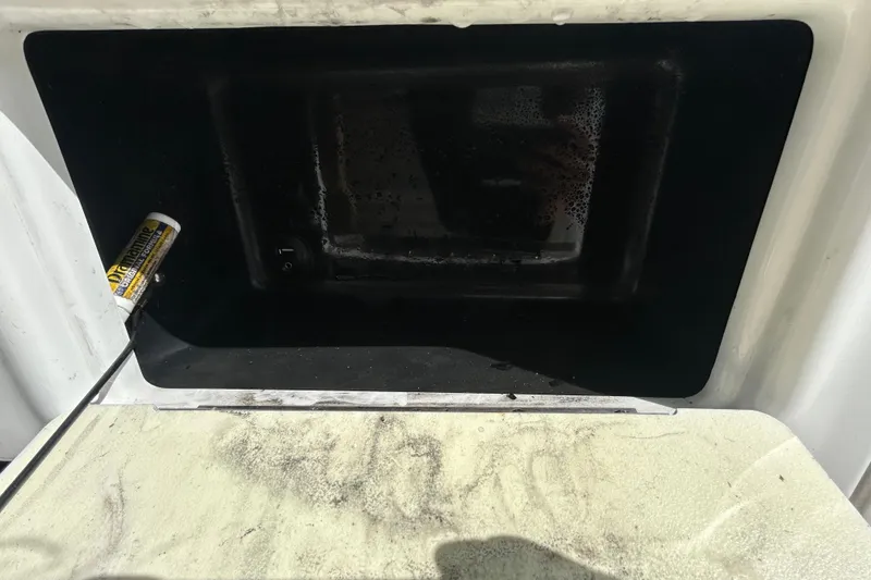 Slide: The Image of Open storage compartment of 2018 NauticStar 28 XS boat with cleaning supplies. - 73