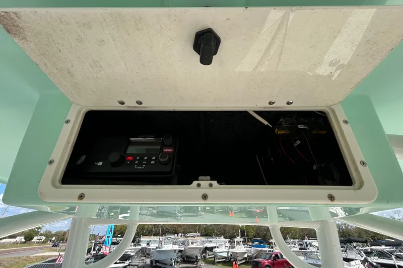Slide: The Image of Open storage compartment on 2018 NauticStar 28 XS boat, showing electronic equipment. - 78