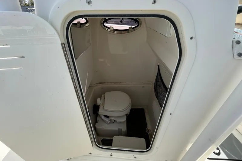 Slide: The Image of 2018 NauticStar 28 XS boat interior with compact marine toilet. - 81