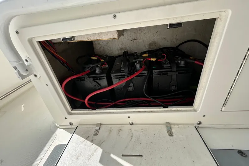 Slide: The Image of Battery compartment of a 2018 NauticStar 28 XS boat with red and black cables. - 99