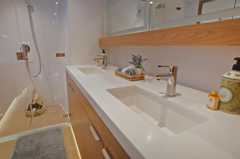 Slide: The Image of Modern bathroom with dual sinks, wooden accents, and a glass shower in a 2026 Bali 5.2 model. - 24