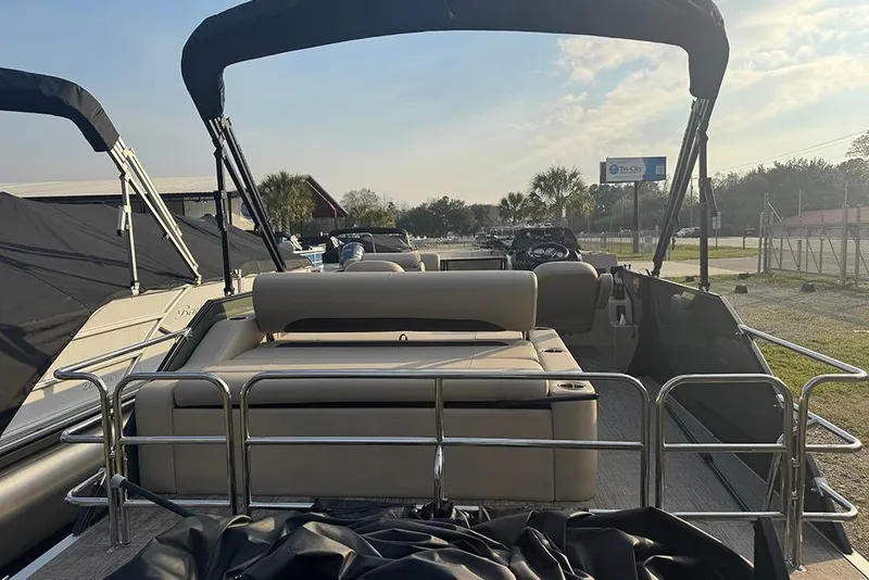 Slide: The Image of 2026 Bentley Pontoons Legacy 223 Swingback with sleek seating and canopy, parked outdoors. - 6