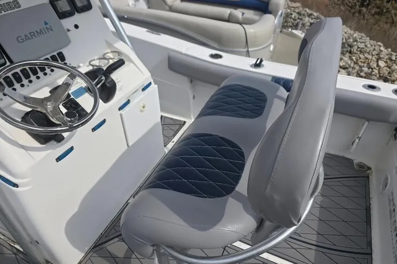Slide: The Image of 2012 Sea Fox 226 Center Console boat interior with steering wheel and cushioned seating. - 6