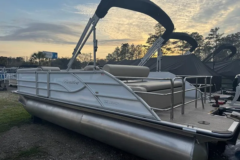 Slide: The Image of 2026 Bentley Pontoons Legacy 223 Swingback at sunset, showcasing sleek design and spacious seating. - 4