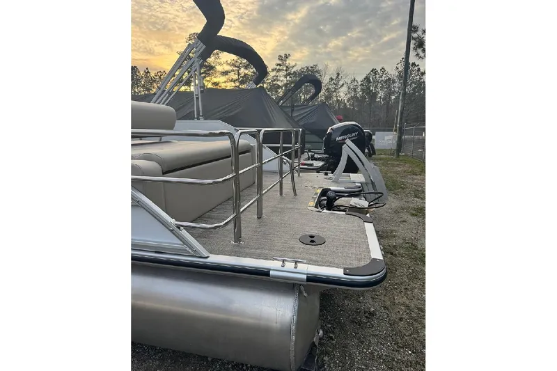 Slide: The Image of 2026 Bentley Pontoons Legacy 223 Swingback at sunset, featuring sleek design and Mercury engine. - 5