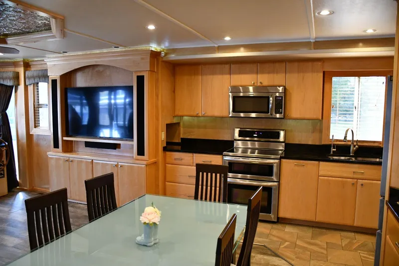 Slide: The Image of Modern kitchen and dining area in 2013 Thoroughbred model, featuring stainless steel appliances and wooden cabinetry. - 28