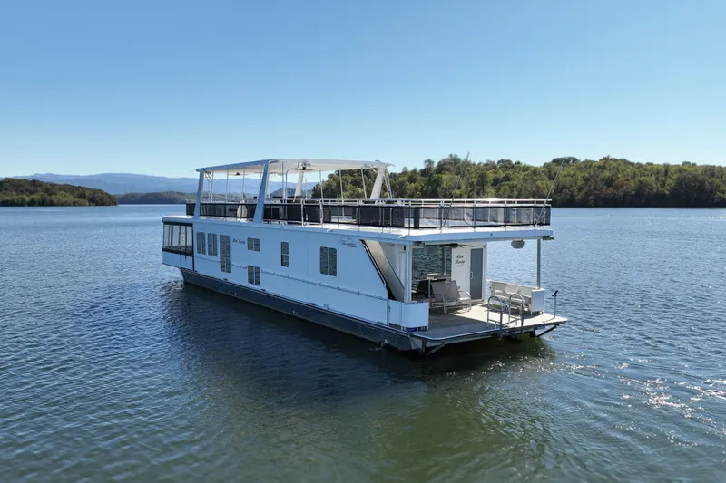 Slide: The Image of 2013 Thoroughbred 80'x 18' houseboat on a serene lake with clear blue skies. - 6