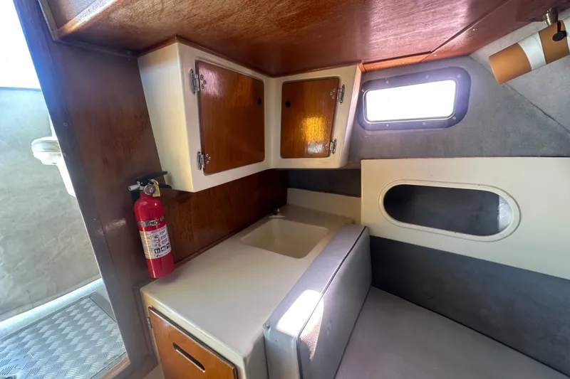 Slide: The Image of 1992 Farallon Whaleback cabin interior with wooden cabinets and a fire extinguisher. - 2