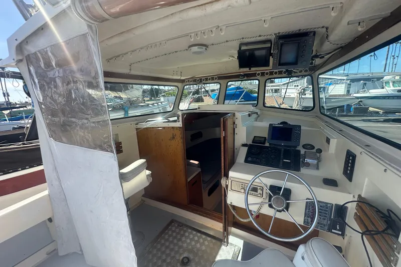 Slide: The Image of Interior of a 1992 Farallon Whaleback boat, featuring steering wheel and navigation equipment. - 4
