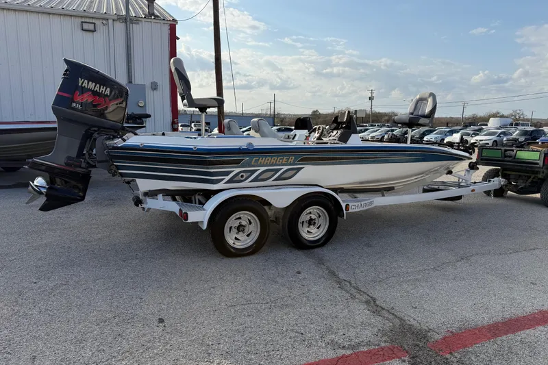 Slide: The Image of 1999 Charger 195TF boat with Yamaha engine on trailer in parking lot. - 16