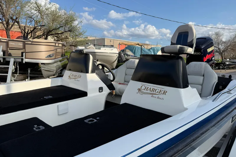 Slide: The Image of 1999 Charger 195TF bass boat with Yamaha engine, parked outdoors under blue sky. - 19