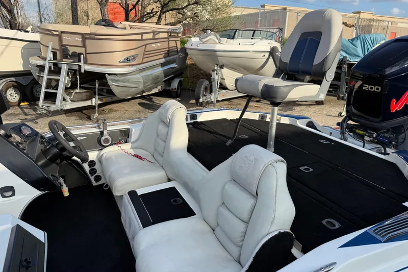 Slide: The Image of Interior of a 1999 Charger 195TF boat with white seating and steering wheel. - 21