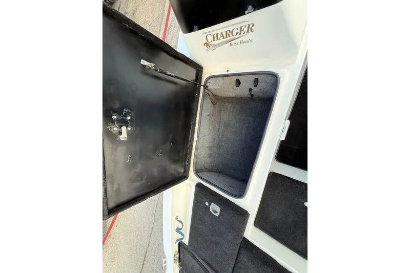 Slide: The Image of Open storage compartment of 1999 Charger 195TF bass boat, showcasing interior space. - 36