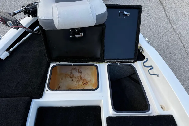 Slide: The Image of 1999 Charger 195TF boat interior with open storage compartments and seating. - 38