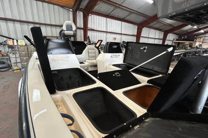 Slide: The Image of 1999 Charger 195TF boat on trailer, parked outdoors under a partly cloudy sky. - 4