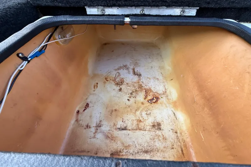 Slide: The Image of 1999 Charger 195TF storage compartment with visible wear and wiring. - 40