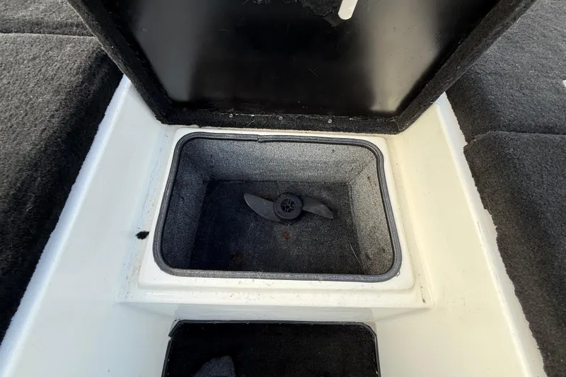 Slide: The Image of Open storage compartment in a 1999 Charger 195TF boat, featuring a propeller inside. - 41