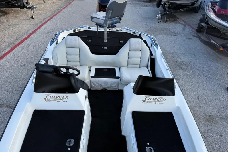 Slide: The Image of 1999 Charger 195TF bass boat interior with white seating and steering console. - 43