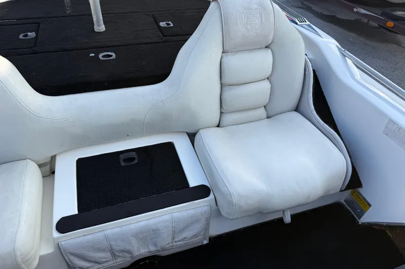 Slide: The Image of 1999 Charger 195TF boat interior with white cushioned seating and black accents. - 45
