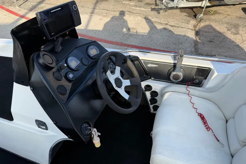 Slide: The Image of Interior of a 1999 Charger 195TF boat with steering wheel and control panel. - 48