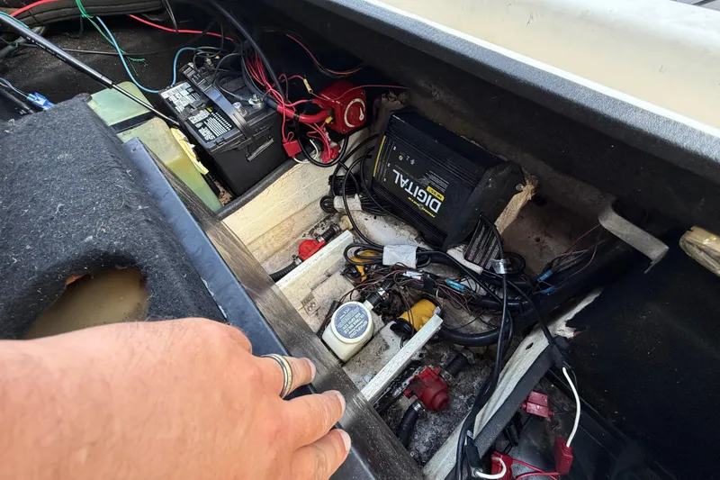 Slide: The Image of 1999 Charger 195TF boat battery compartment with wiring and digital components. - 54