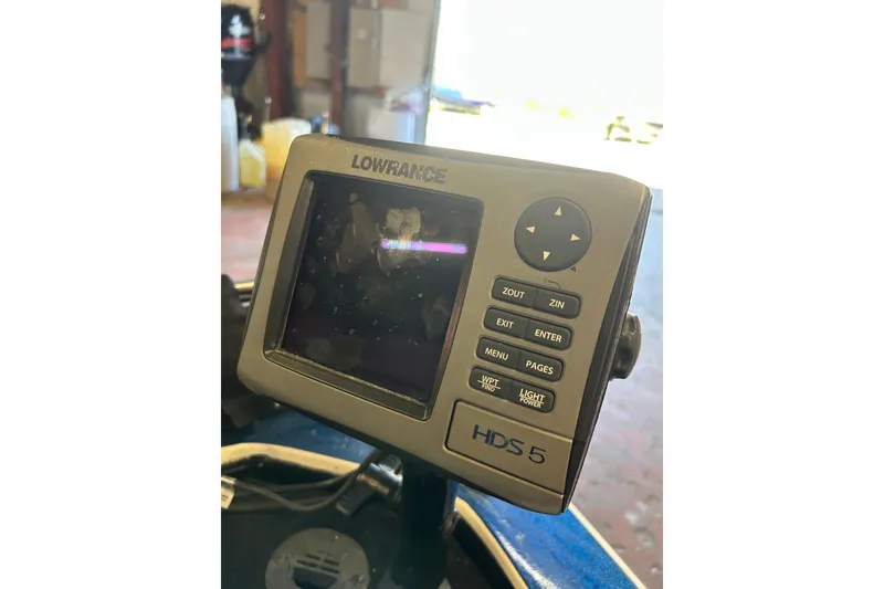 Slide: The Image of 1999 Charger 195TF boat on trailer, featuring MotorGuide equipment, parked outdoors. - 6