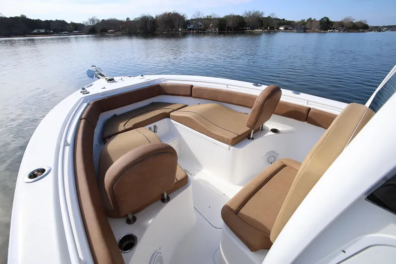 Slide: The Image of 2020 Sea Hunt Ultra 255 SE boat interior with tan seating on a calm lake. - 17
