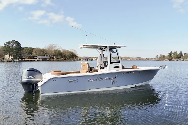 Slide: The Image of 2020 Sea Hunt Ultra 255 SE boat on calm water with Yamaha outboard motor. - 2