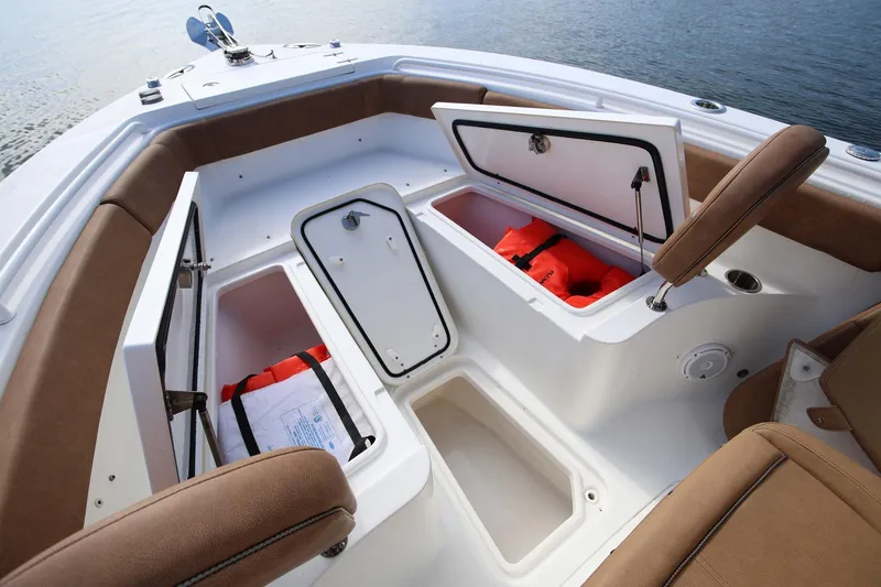 Slide: The Image of 2020 Sea Hunt Ultra 255 SE boat interior with open storage compartments and life jackets. - 26