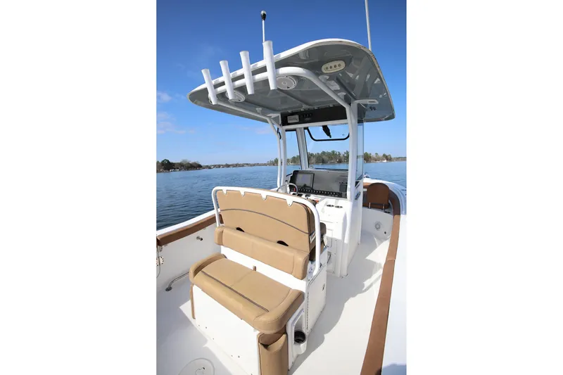 Slide: The Image of 2020 Sea Hunt Ultra 255 SE boat interior with seating and console on a calm lake. - 9