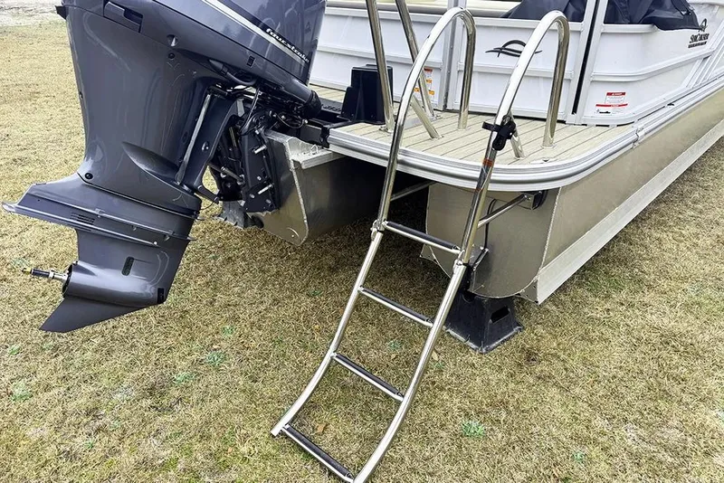 Slide: The Image of 2026 SunCatcher Fusion 324SL boat with motor and ladder on grassy area. - 10
