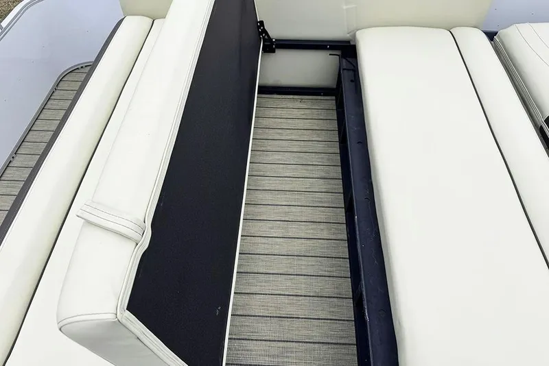 Slide: The Image of 2026 SunCatcher Fusion 324SL boat interior with white cushioned seating and storage space. - 35