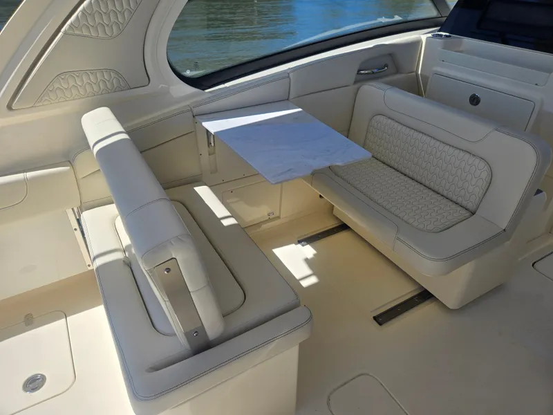 Slide: The Image of The image shows the interior of a Scout 288 Dorado boat with beige upholstered seating and a table. - 8