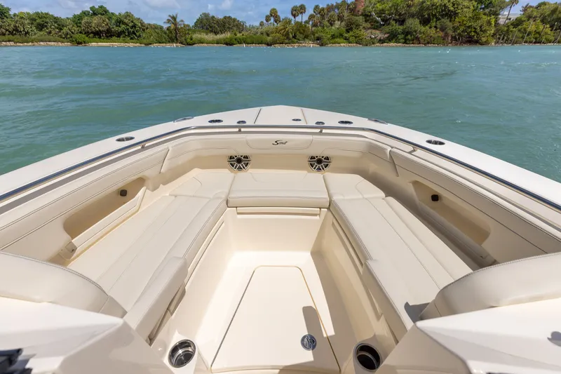 Slide: The Image of The image shows the bow seating area of a Scout 288 Dorado boat on calm waters. - 0