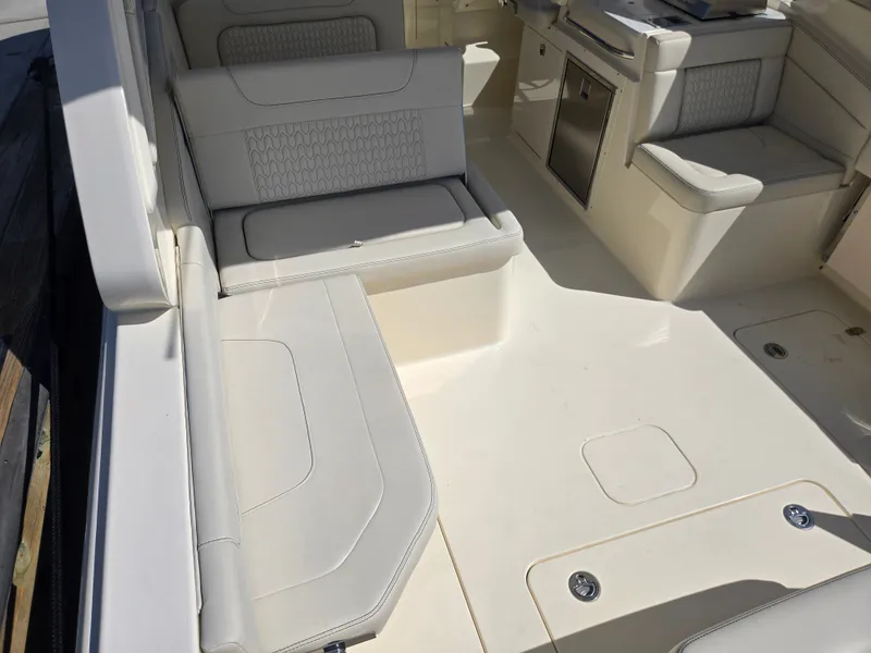 Slide: The Image of The image shows the cockpit of a Scout 288 Dorado boat with beige upholstery and seating. - 5