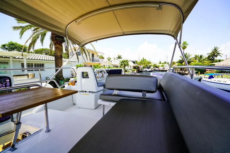 Slide: The Image of 2017 Azimut 42 Fly yacht with shaded seating and table, docked in a sunny marina. - 15