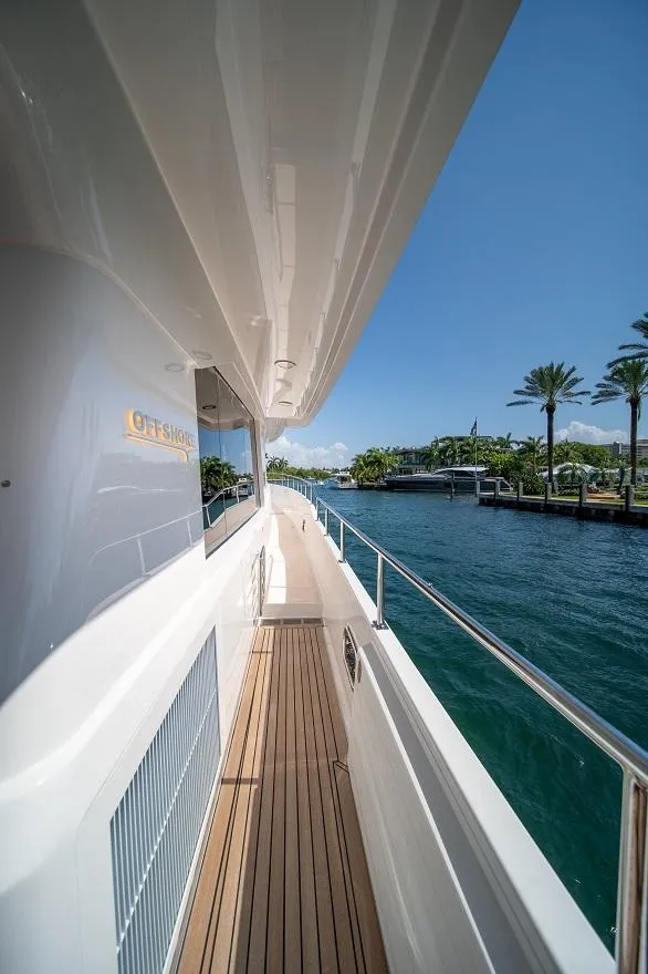 Slide: The Image of 2026 Offshore Yachts CE Series, sleek deck view, cruising along a scenic waterfront. - 10