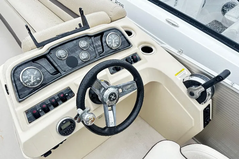 Slide: The Image of 2019 Godfrey Sweetwater 2386 C boat dashboard with steering wheel and controls. - 2
