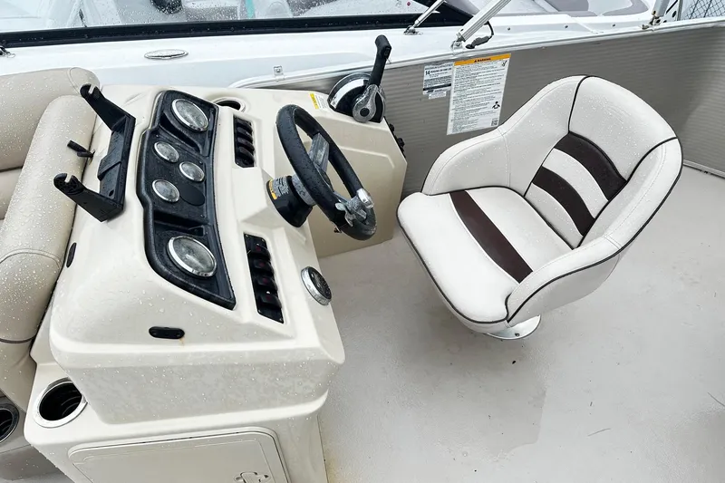 Slide: The Image of 2019 Godfrey Sweetwater 2386 C boat helm with steering wheel and cushioned captain's chair. - 3