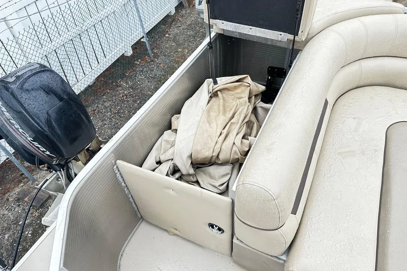 Slide: The Image of 2019 Godfrey Sweetwater 2386 C boat interior with storage compartment and Mercury outboard motor. - 7