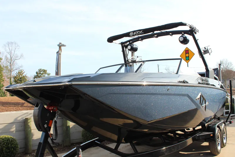 Slide: The Image of 2026 ATX Surf Boats 24 Type-S, sleek design, parked on trailer, outdoor setting. - 6