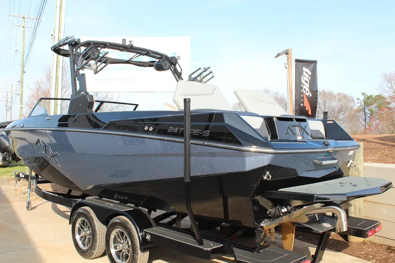Slide: The Image of 2026 ATX Surf Boats 24 Type-S, sleek black design on trailer, outdoor display. - 8