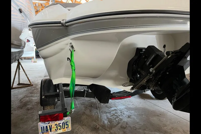 Slide: The Image of 2019 Stingray 208 LS boat on trailer, featuring MerCruiser engine, in a storage facility. - 13