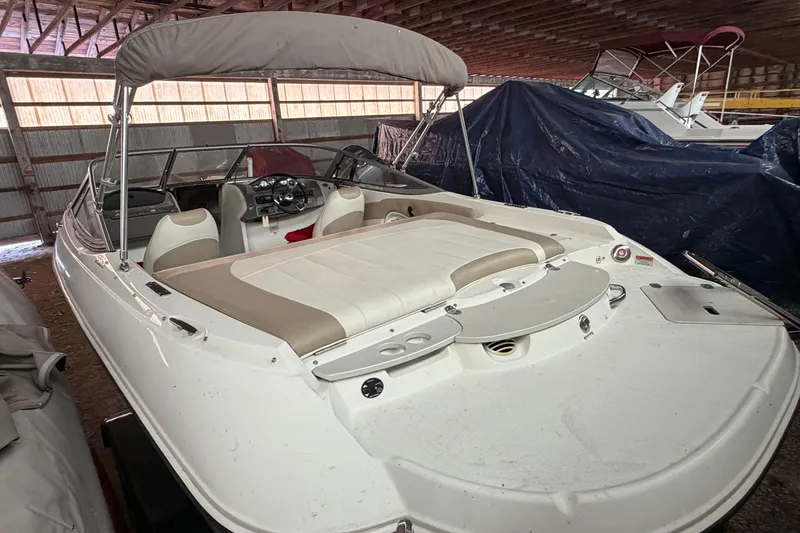 Slide: The Image of 2019 Stingray 208 LS boat with canopy in indoor storage. - 14