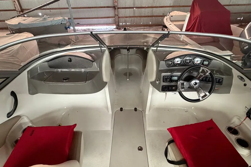 Slide: The Image of 2019 Stingray 208 LS boat interior with steering wheel and dashboard in a storage facility. - 16