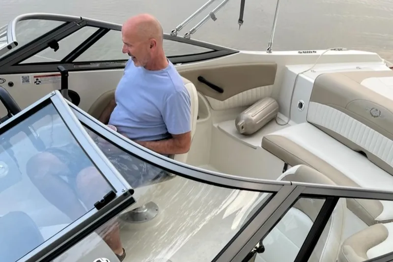Slide: The Image of Man seated in a 2019 Stingray 208 LS boat, enjoying a calm water setting. - 21