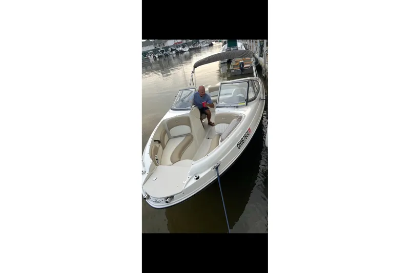 Slide: The Image of 2019 Stingray 208 LS boat docked with a person seated inside. - 22